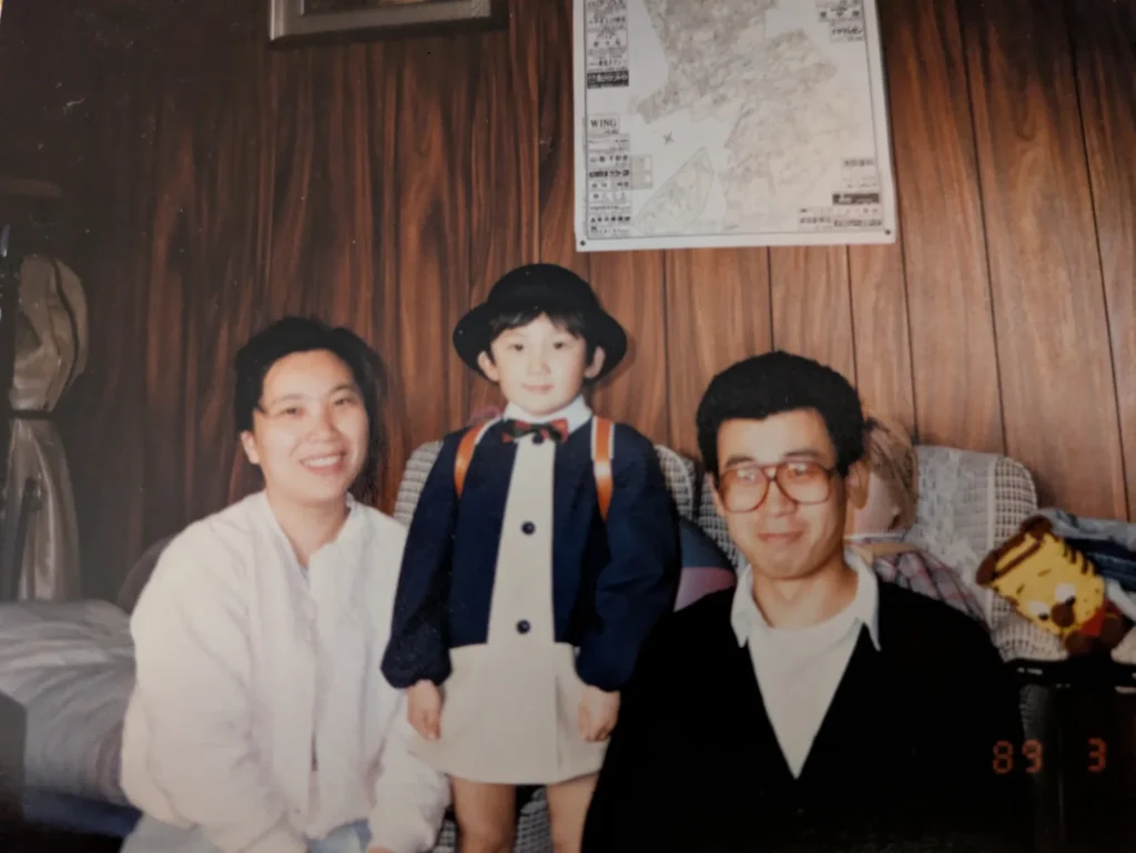 幼少期の山中健太先生と両親が並ぶ家族写真